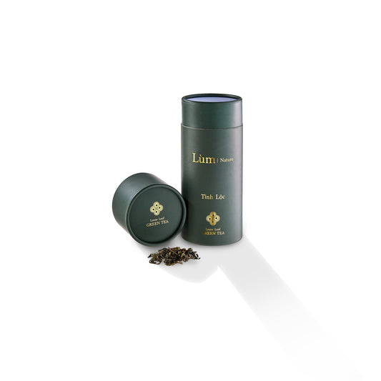 Lùm Nature Tinh Lộc loose leaf green tea tin with lid and loose tea leaves on white background